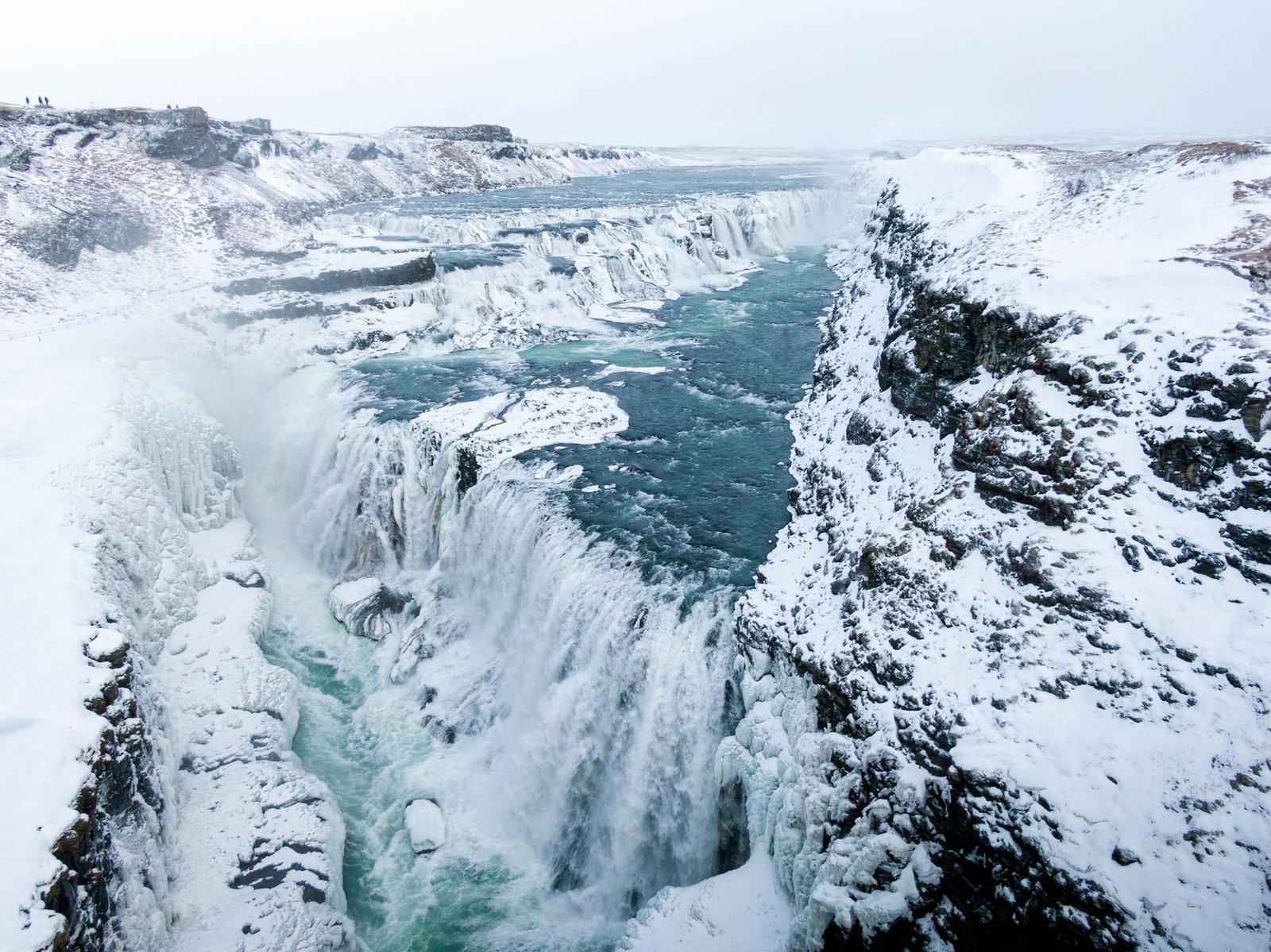 Freezing cold icelandic waterfall in the depths of winter with snow on the ground.